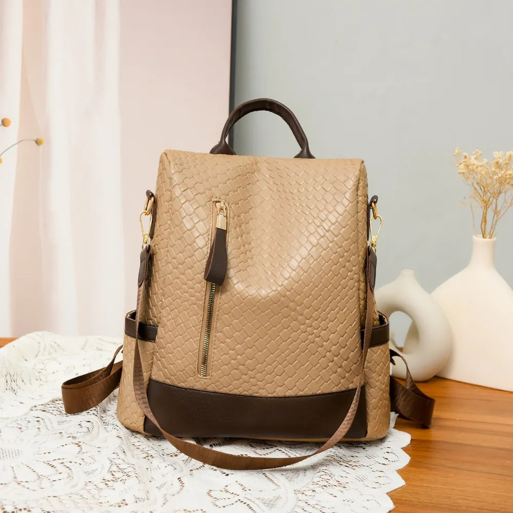 Vegan leather backpack bag in tan with braided texture, front zipper, and side pockets.