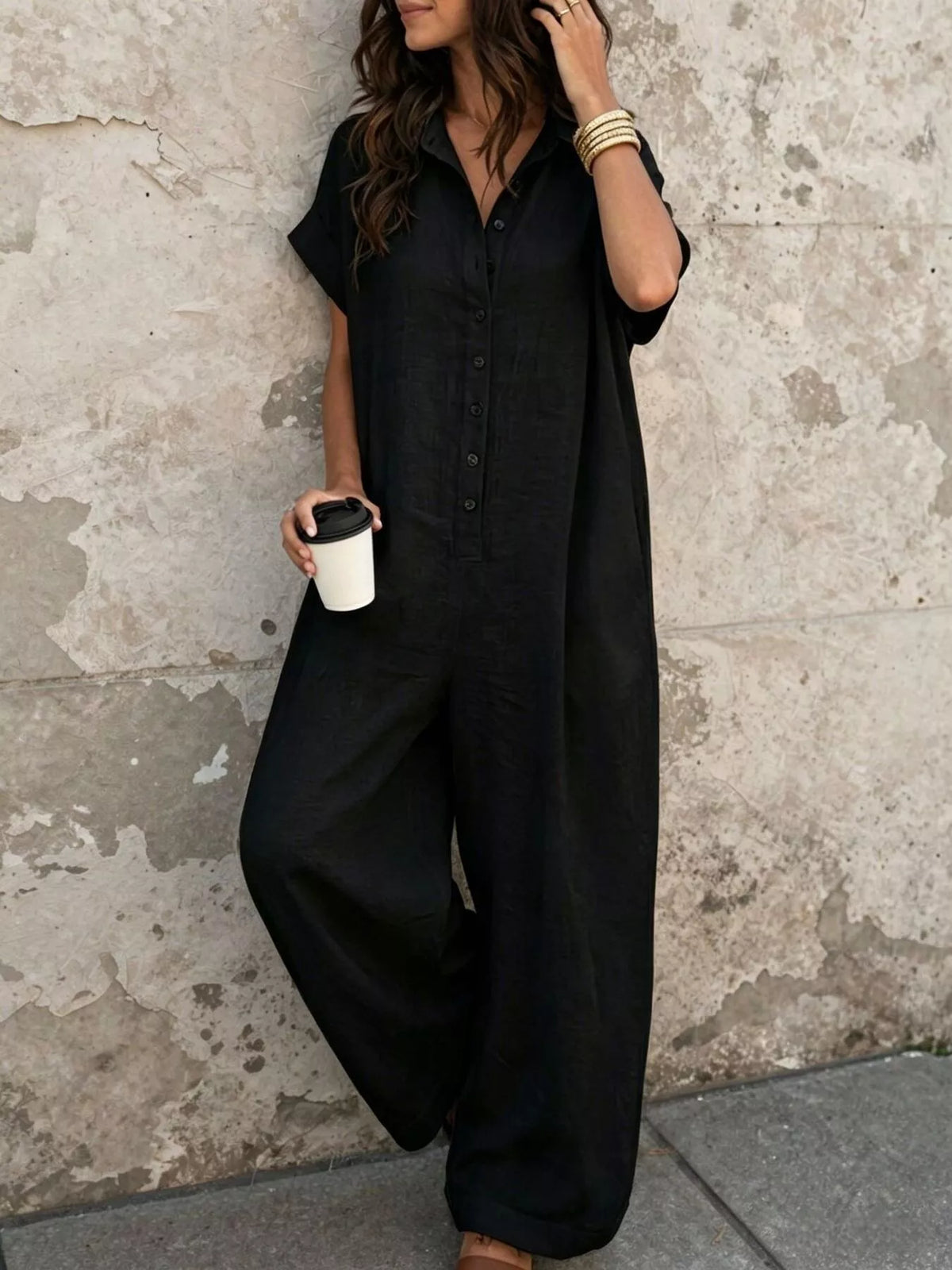Black button-front short-sleeve jumpsuit with wide legs and chest pockets