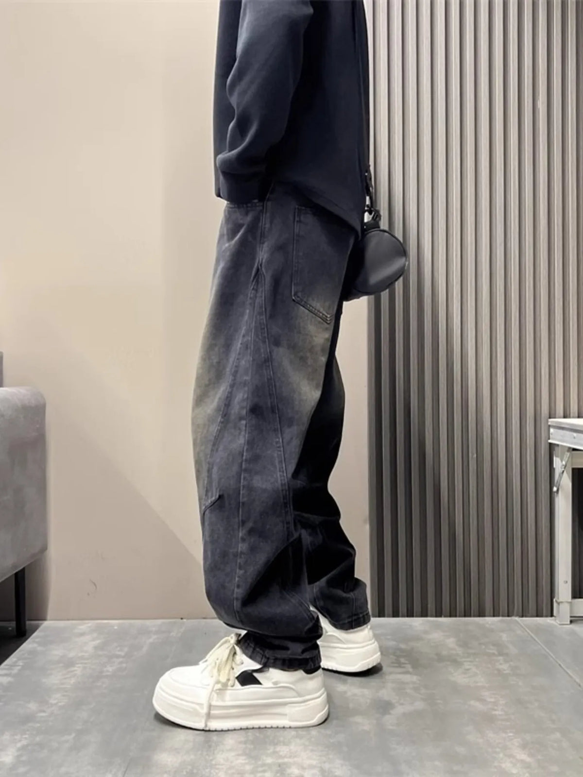 Washed black loose jeans with relaxed fit, tapered ankle cuff, and side pockets