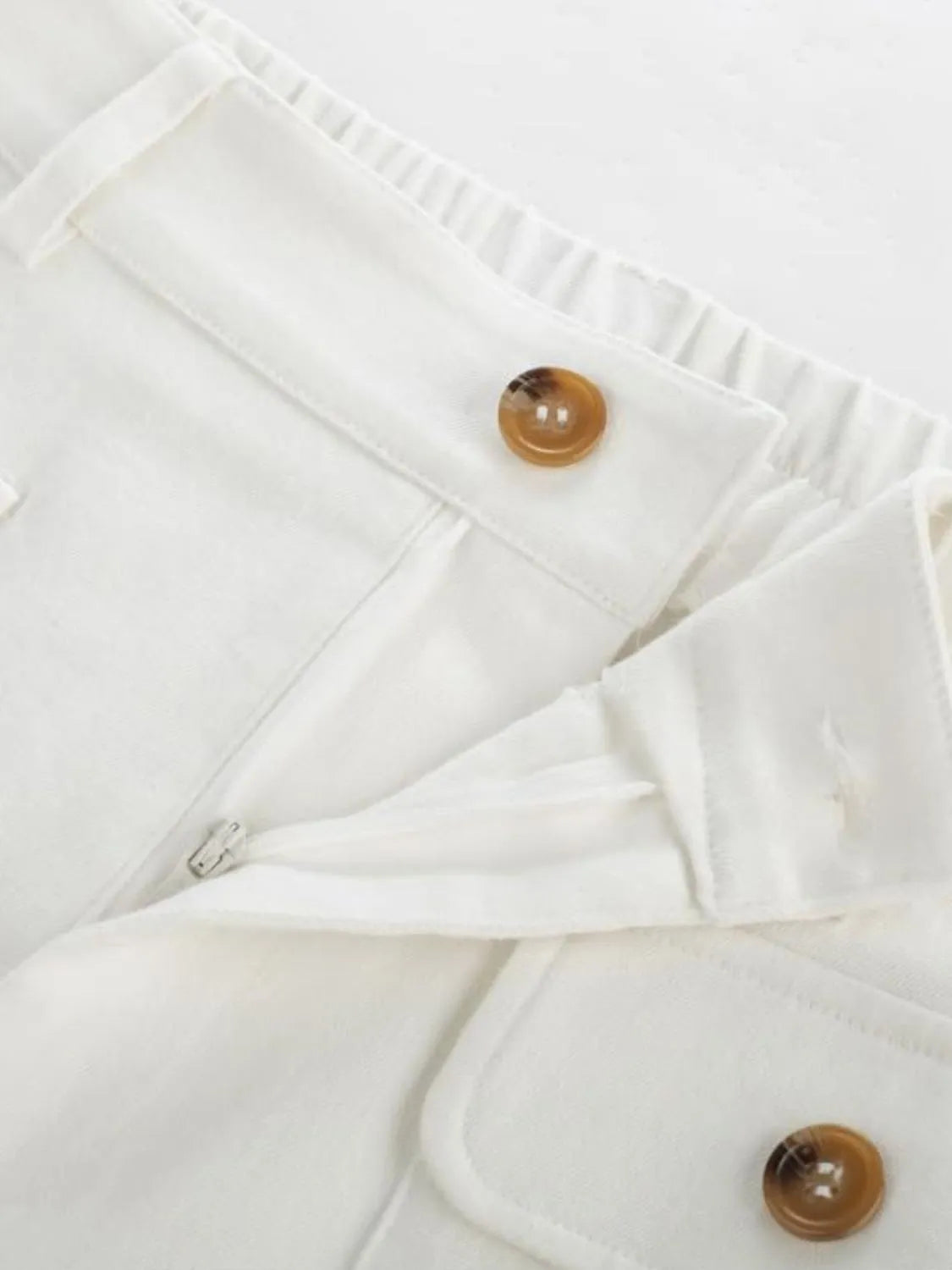 White wide-leg pants detail: ruffled elastic waistband and brown button