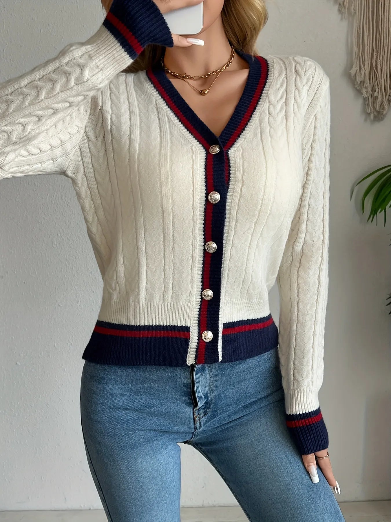 Ivory cable-knit V-neck cardigan with contrast navy-red button placket and cuffs