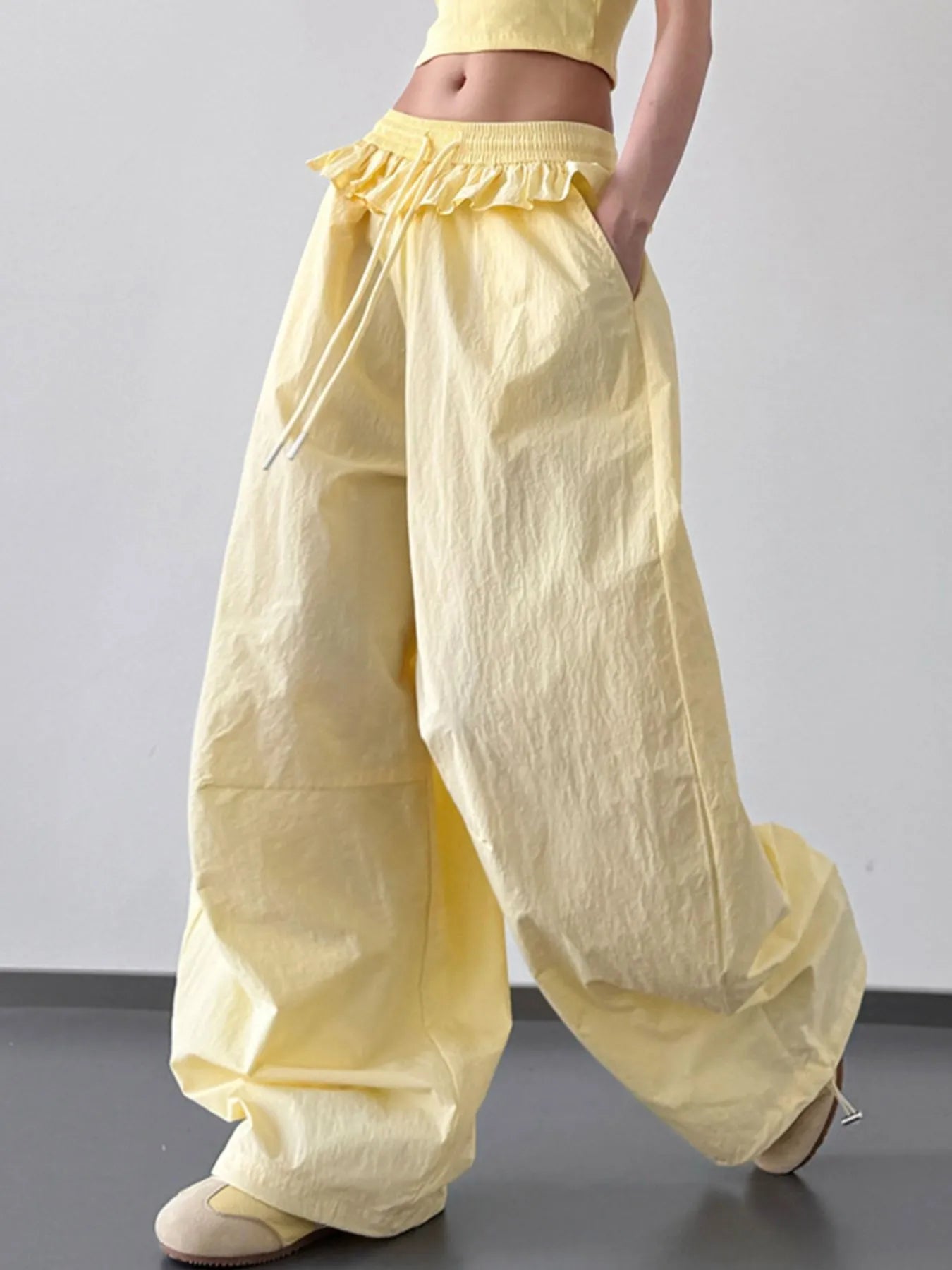 Yellow drawstring wide-leg pants with ruffled waistband and loose balloon shape