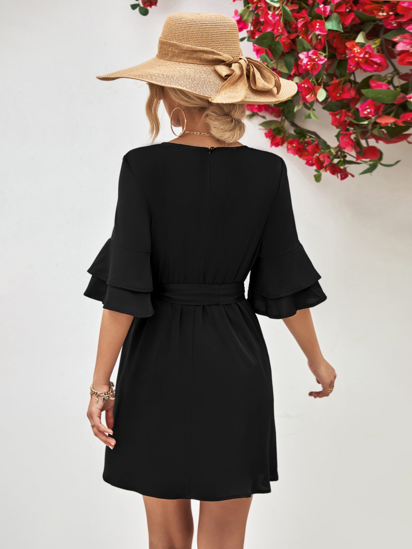 Black round-neck dress with tie belt and flounce sleeves, shown from back