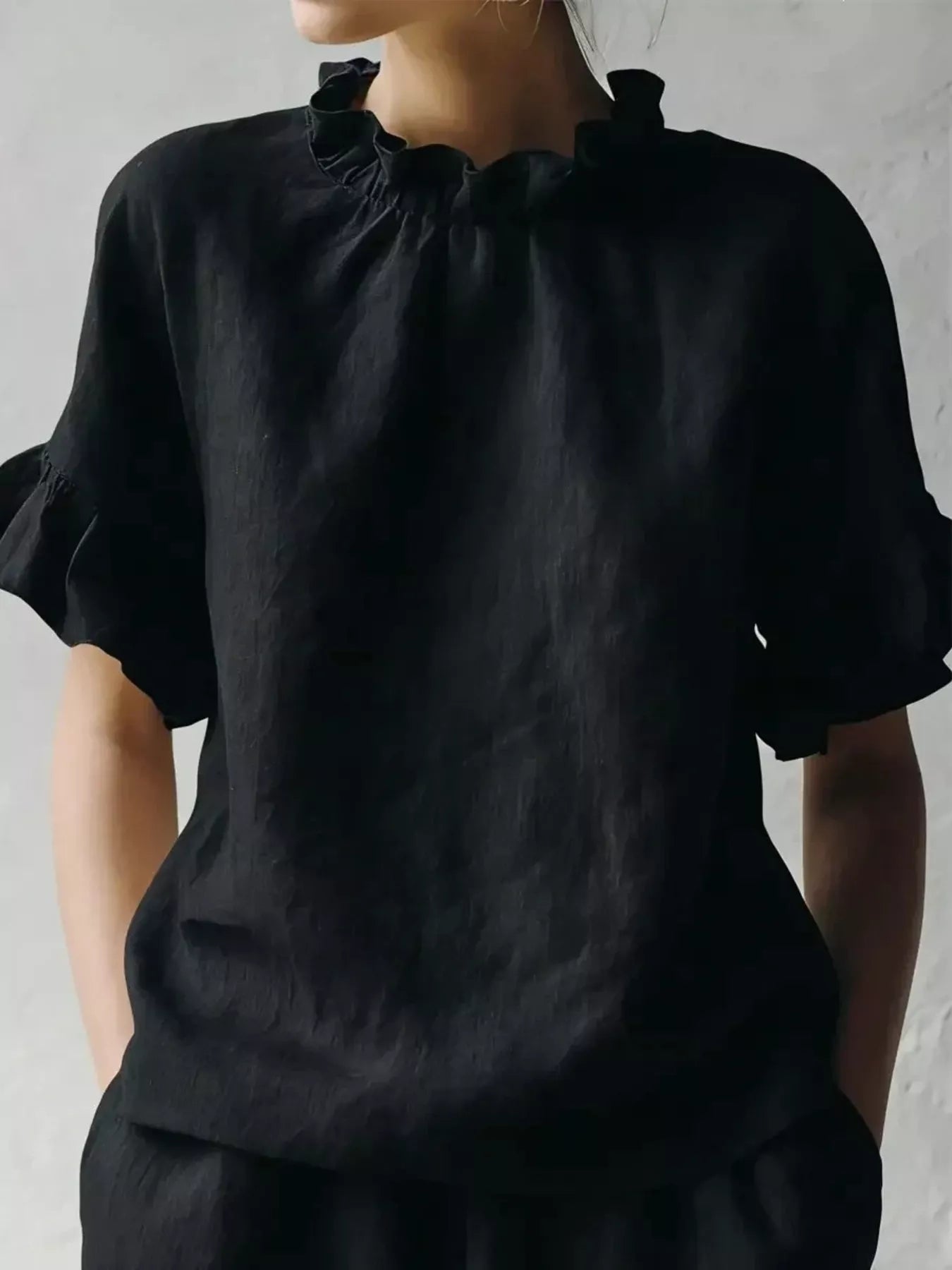 Black ruffled neck half-sleeve blouse with gathered high neckline and loose silhouette