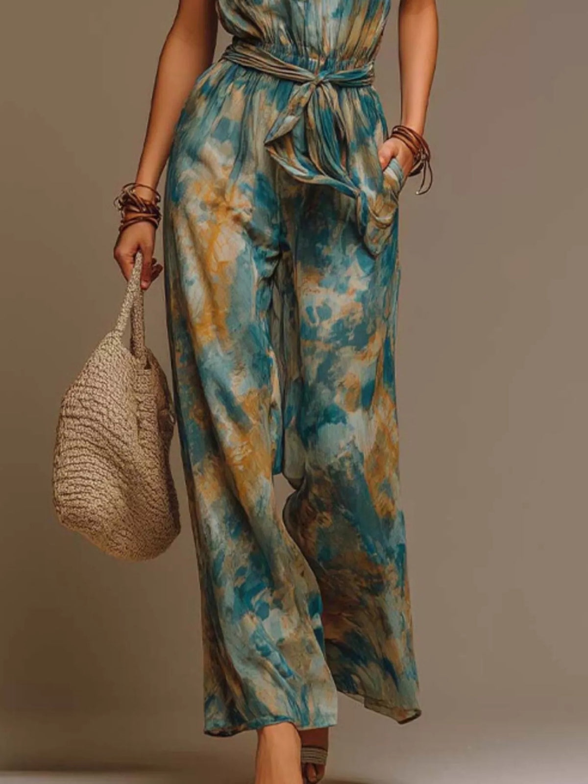 Teal and green tie-dye halter wide-leg jumpsuit with tied waist belt, draped legs