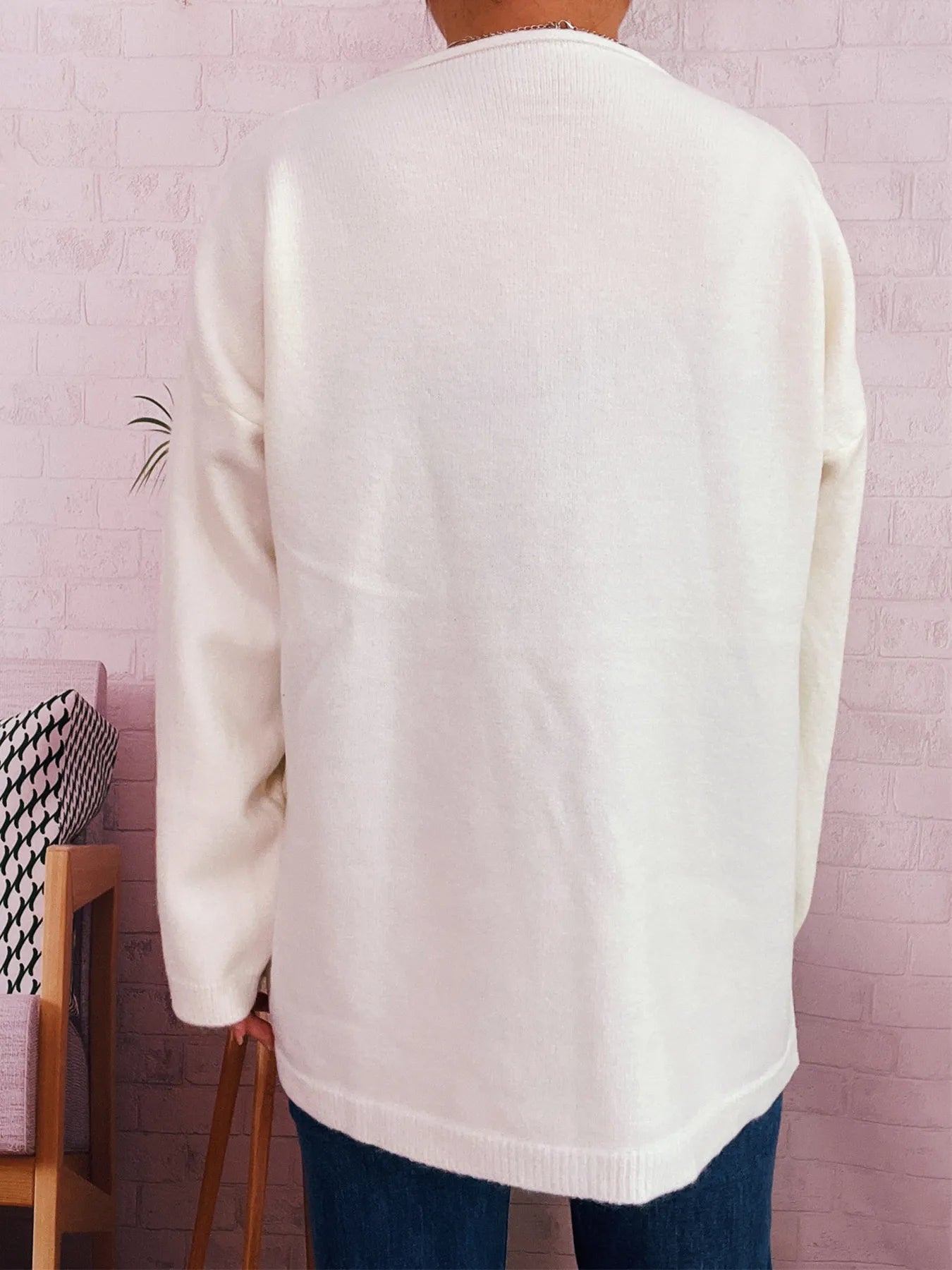 White drop-shoulder cardigan with crew neck and single button front, long sleeves
