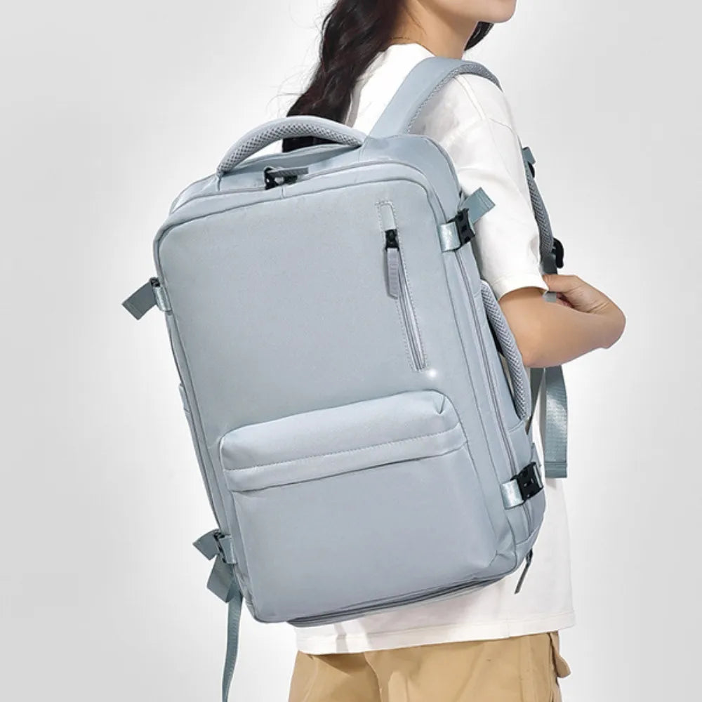 Light blue oxford backpack with side pockets, front zipper, padded handle and straps