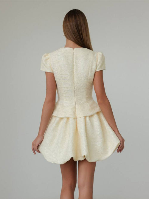 Cream short-sleeve button-up top and bubble-hem skirt set, back view.