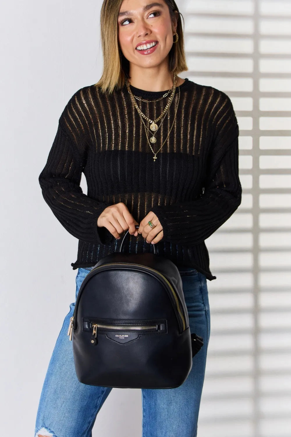 Black vegan leather mini backpack with front zip pocket and gold-tone hardware
