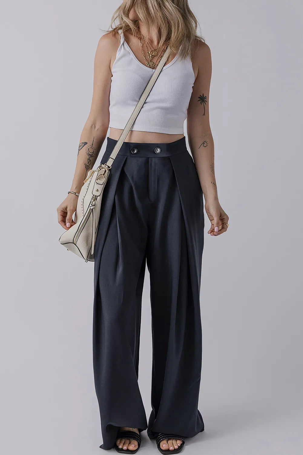 Dark navy wide-leg trousers with pockets, pleats, and buttoned waist at front.