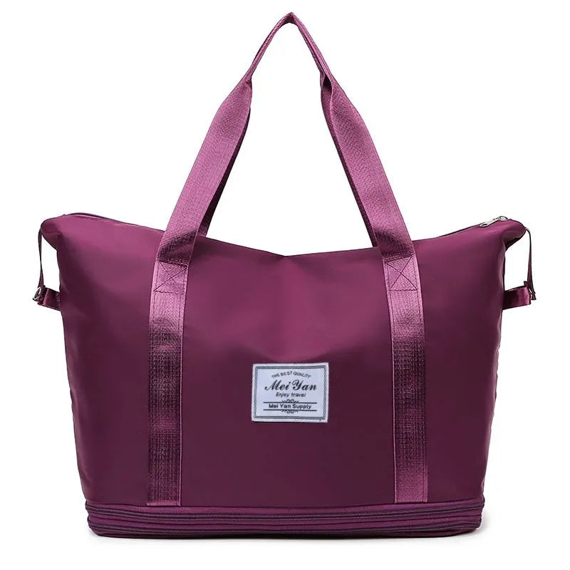 Plum purple large duffle bag with two top handles, side straps, and front logo patch