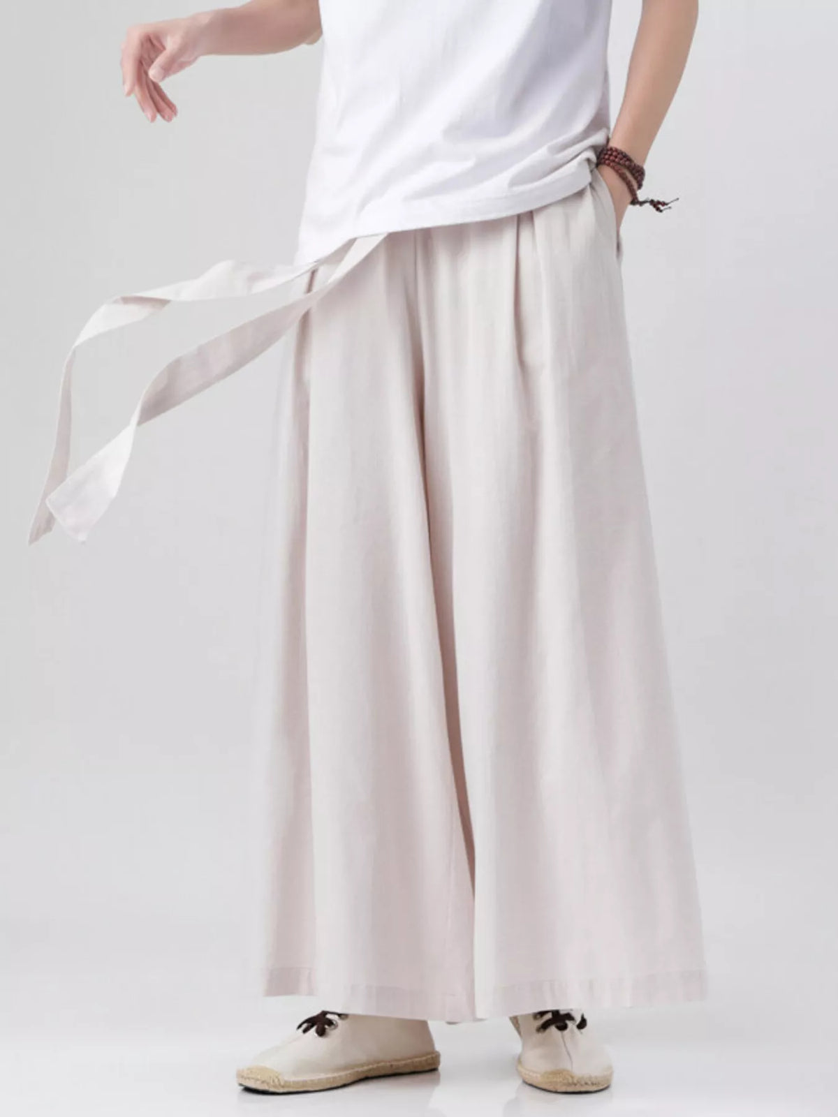 Ivory wide-leg pants with pleated front and loose drape at the hem
