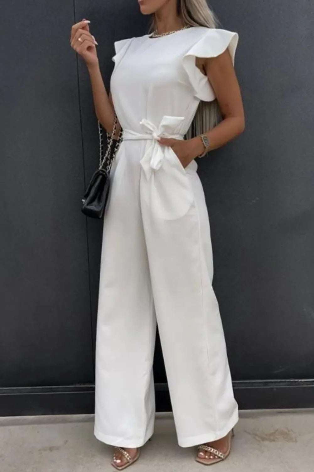 White round-neck cap-sleeve jumpsuit with waist tie and flowing wide-leg pants