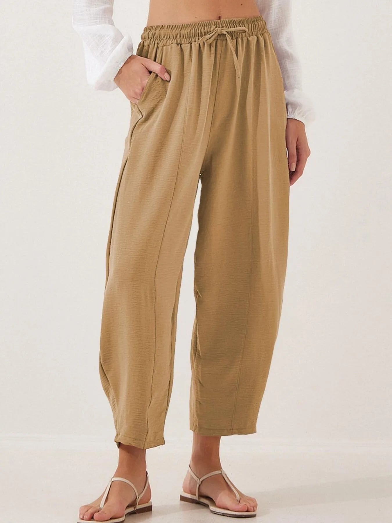 Cropped wide-leg pants in tan with elastic waist and drawstring