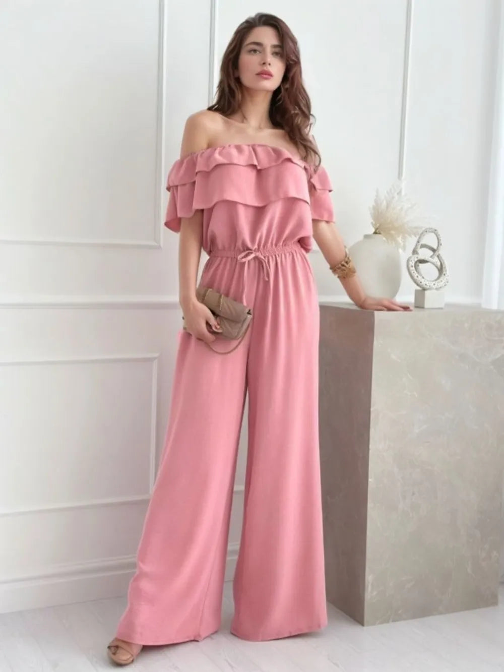 Dusty pink off-shoulder ruffled jumpsuit with layered neckline and wide straight legs