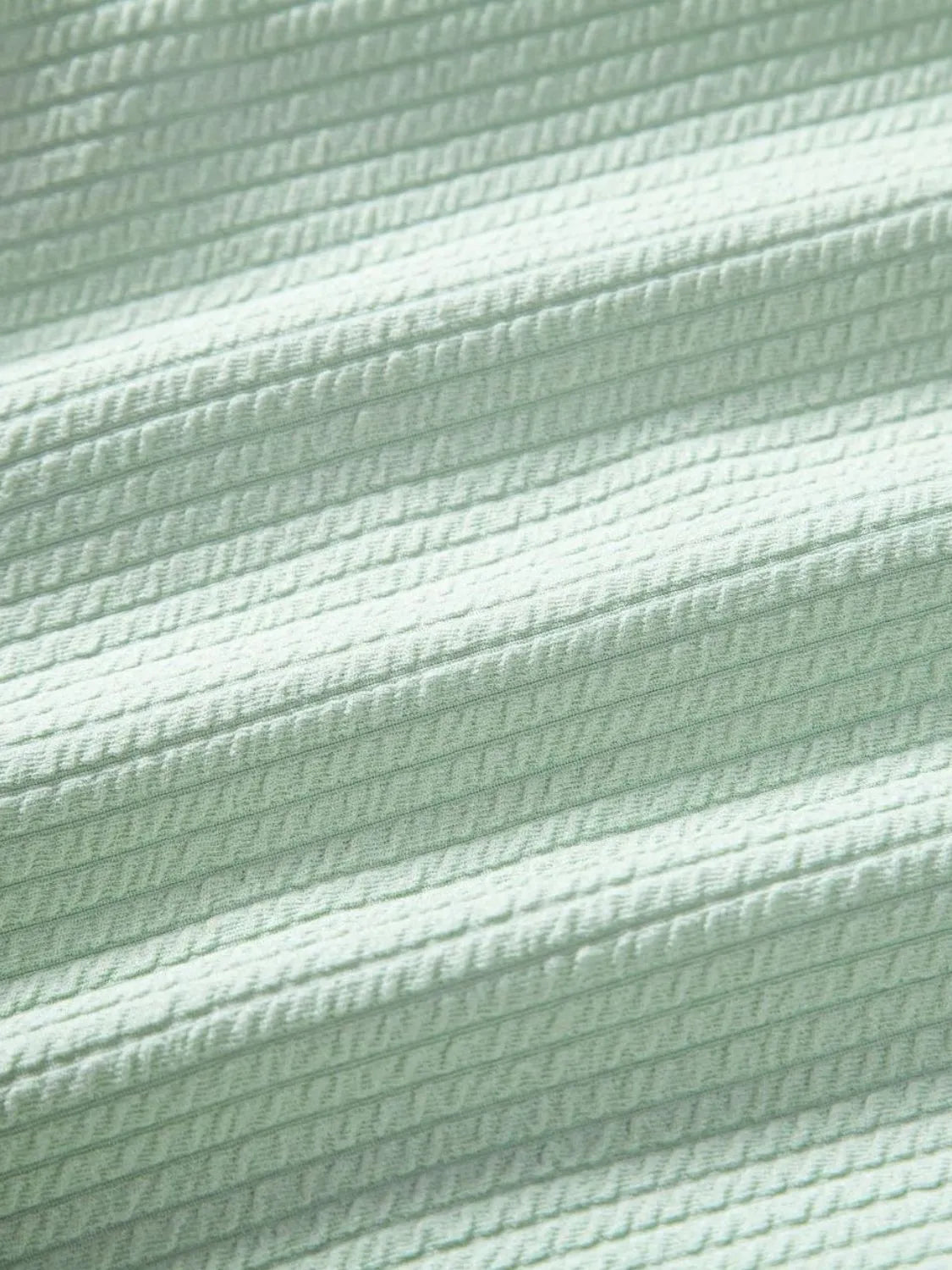 Mint green ribbed fabric close-up with woven texture