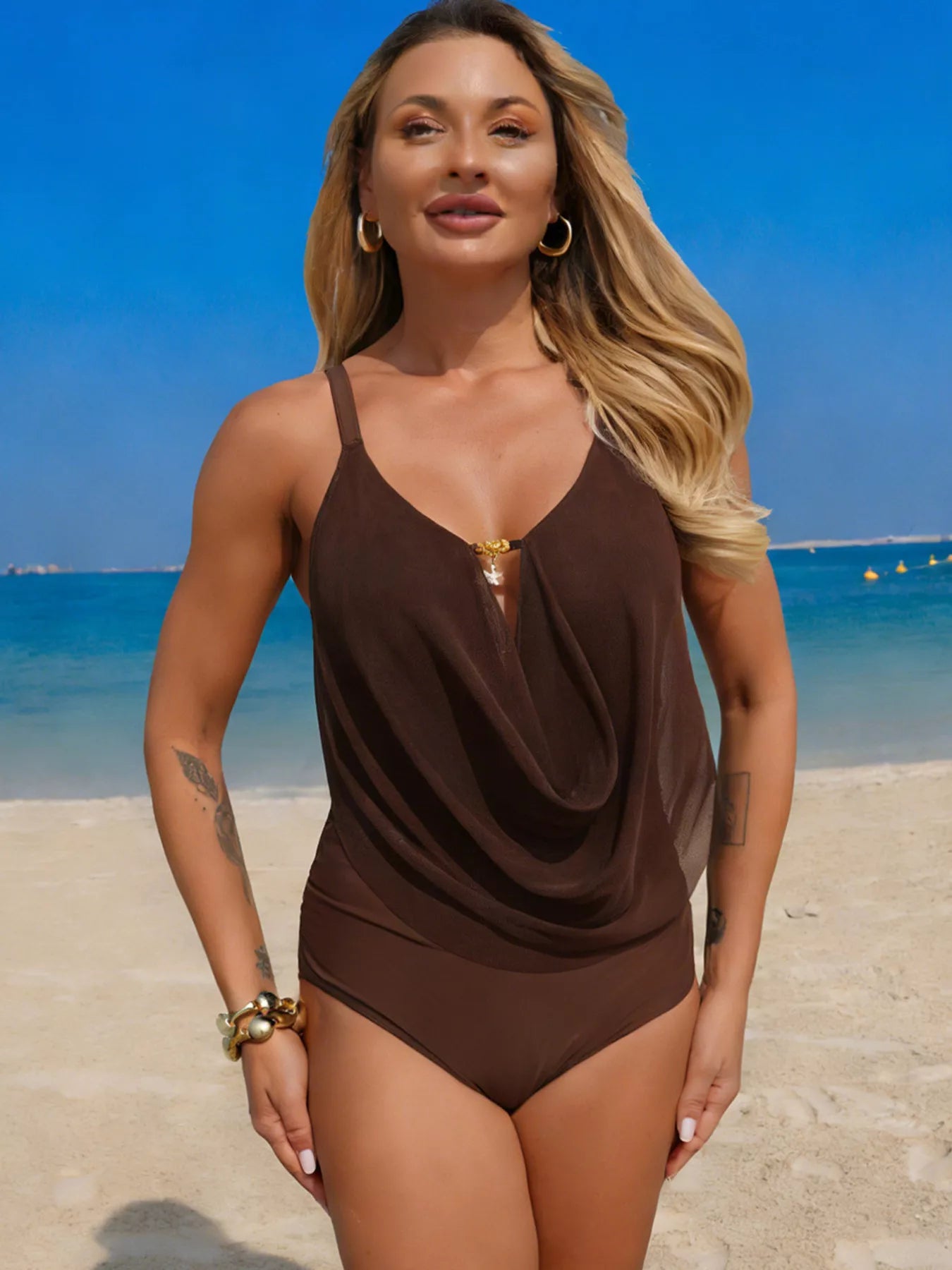 One-piece swimsuit with ruched draped brown front on a model at the beach