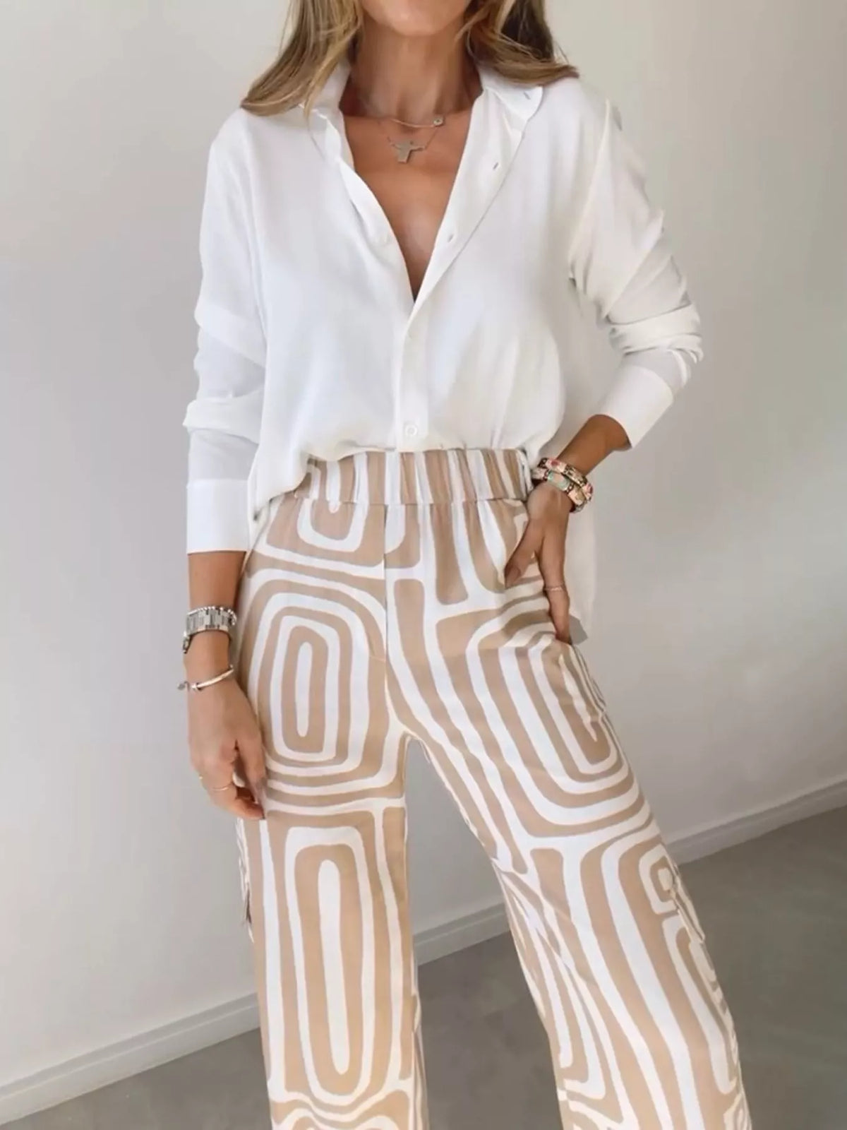 Button-down shirt with geometric print pants set in cream with tan outlines.