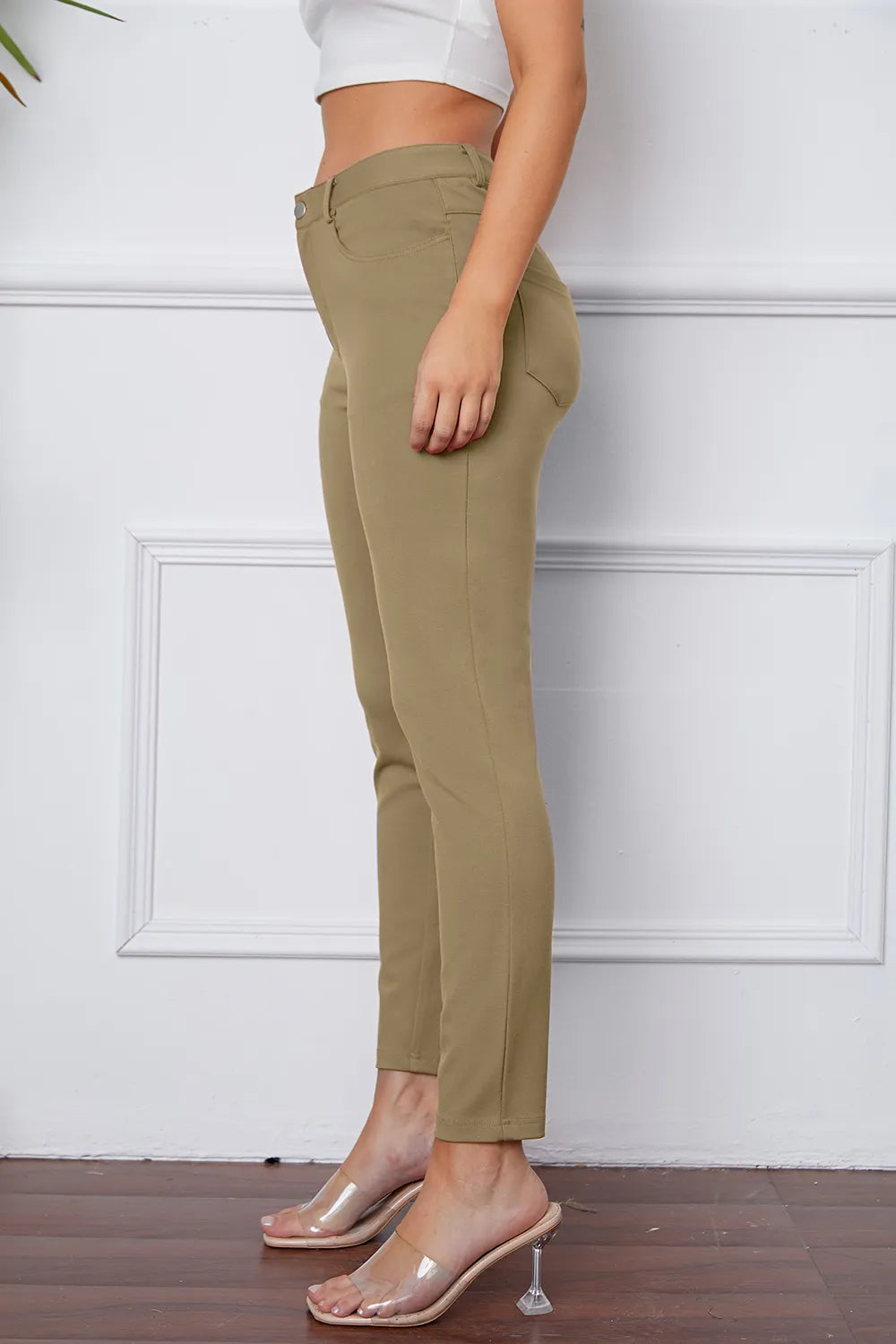 Women's khaki stretch pants, side view, with button and belt loops