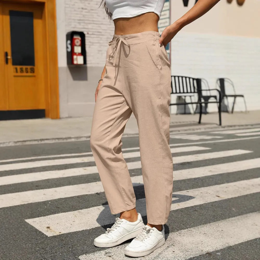 Beige tapered pants with elastic waist and drawstring tie at center front
