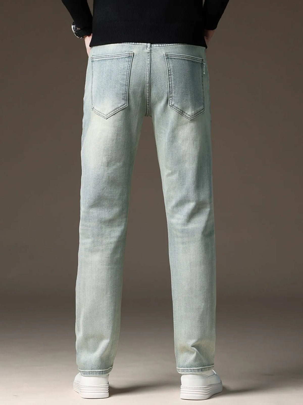 Light wash straight-leg jeans, back view with stitched patch pockets