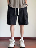 Men's black cargo shorts with drawstring waist and side flap pockets