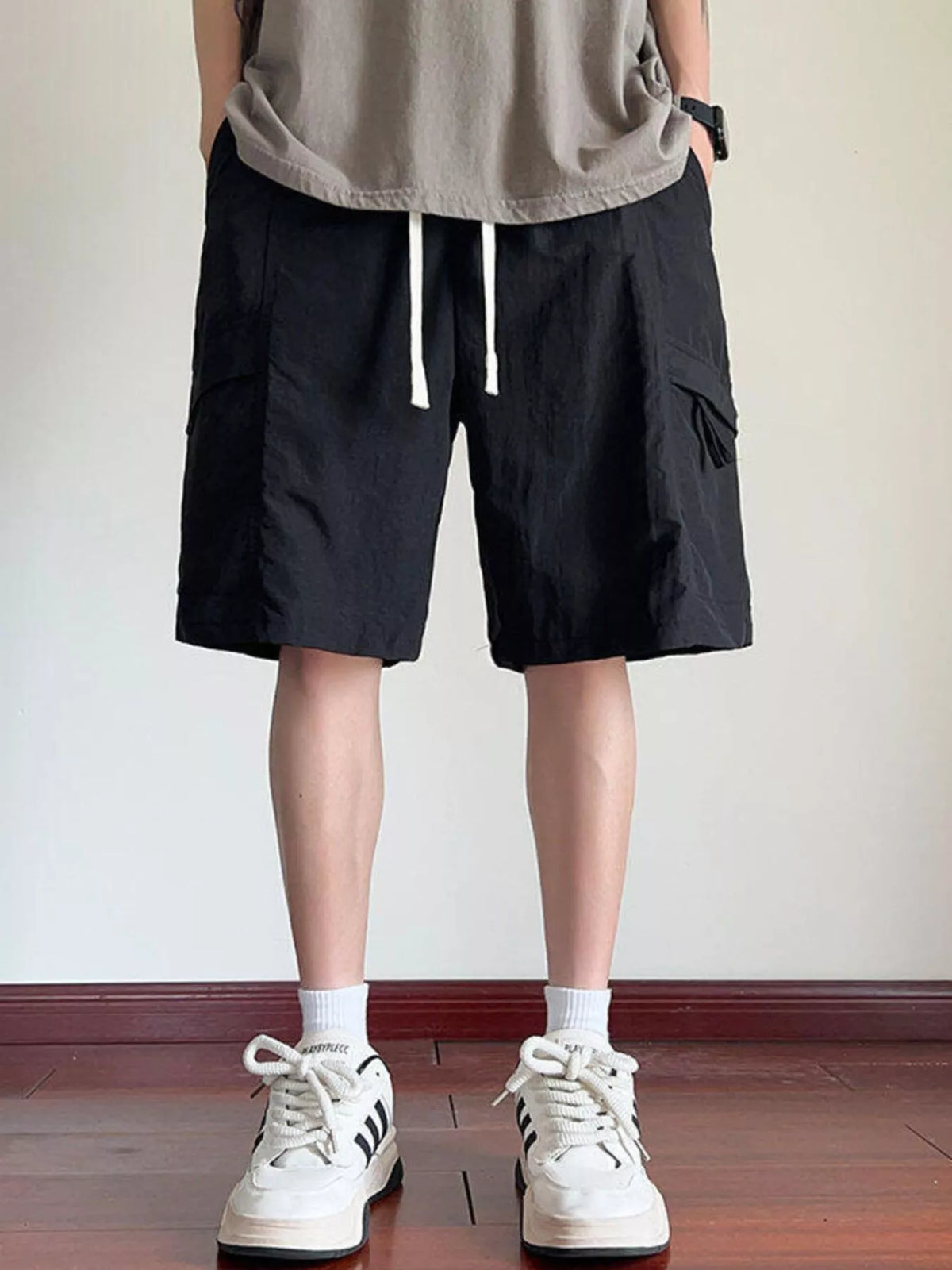 Men's black cargo shorts with drawstring waist and side flap pockets