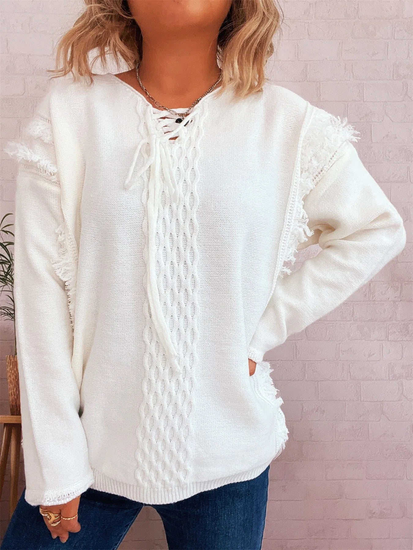 White lace-up sweater with cable knit front panel and raw-edge shoulders