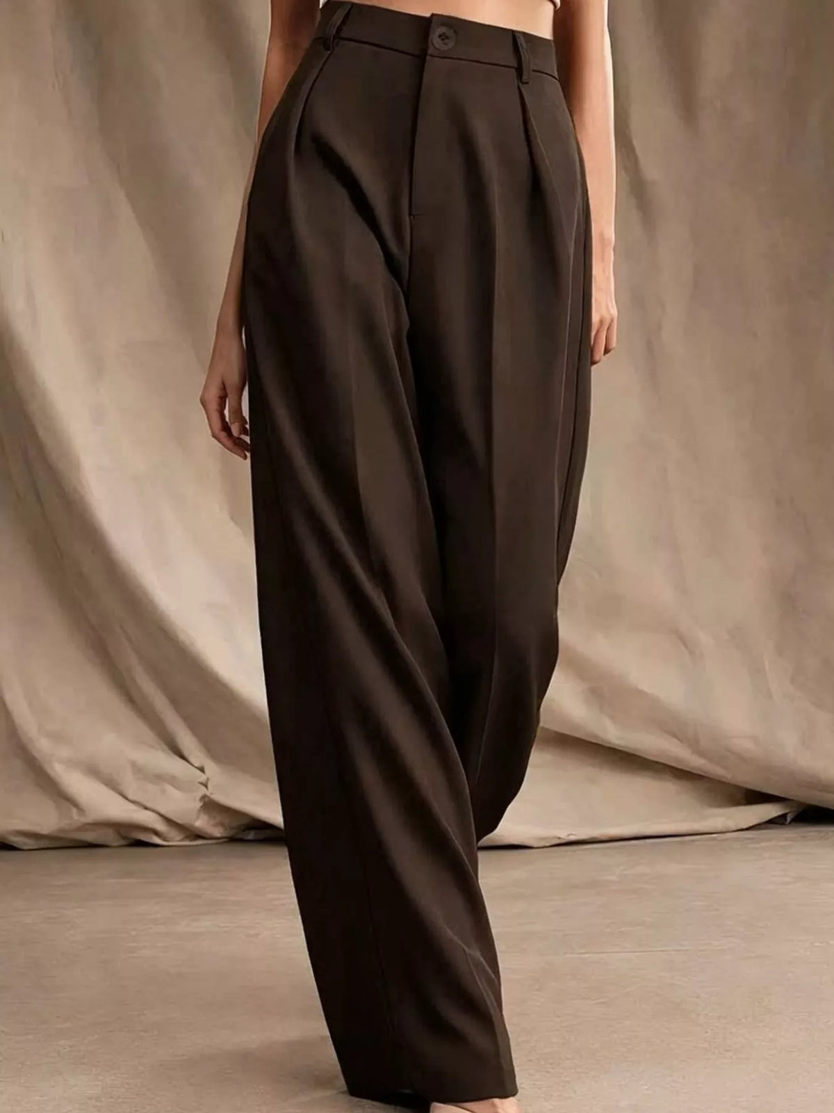 Dark brown high-waisted pleated wide-leg pants with button closure and belt loops