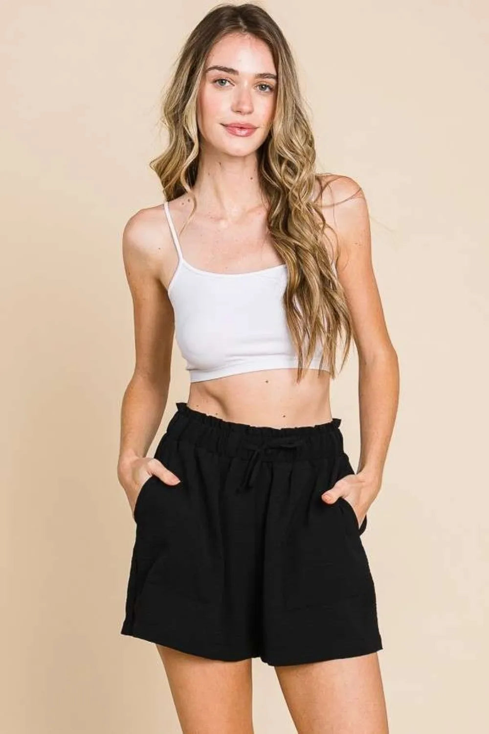 Black high-waist paper bag shorts with elastic waistband and pleated front
