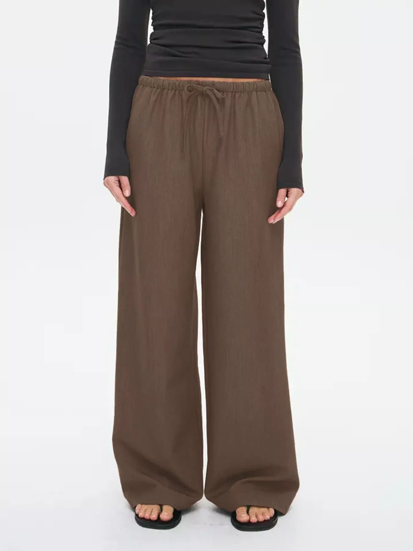 Brown wide-leg drawstring pants with elastic waistband and wide, flowing legs.