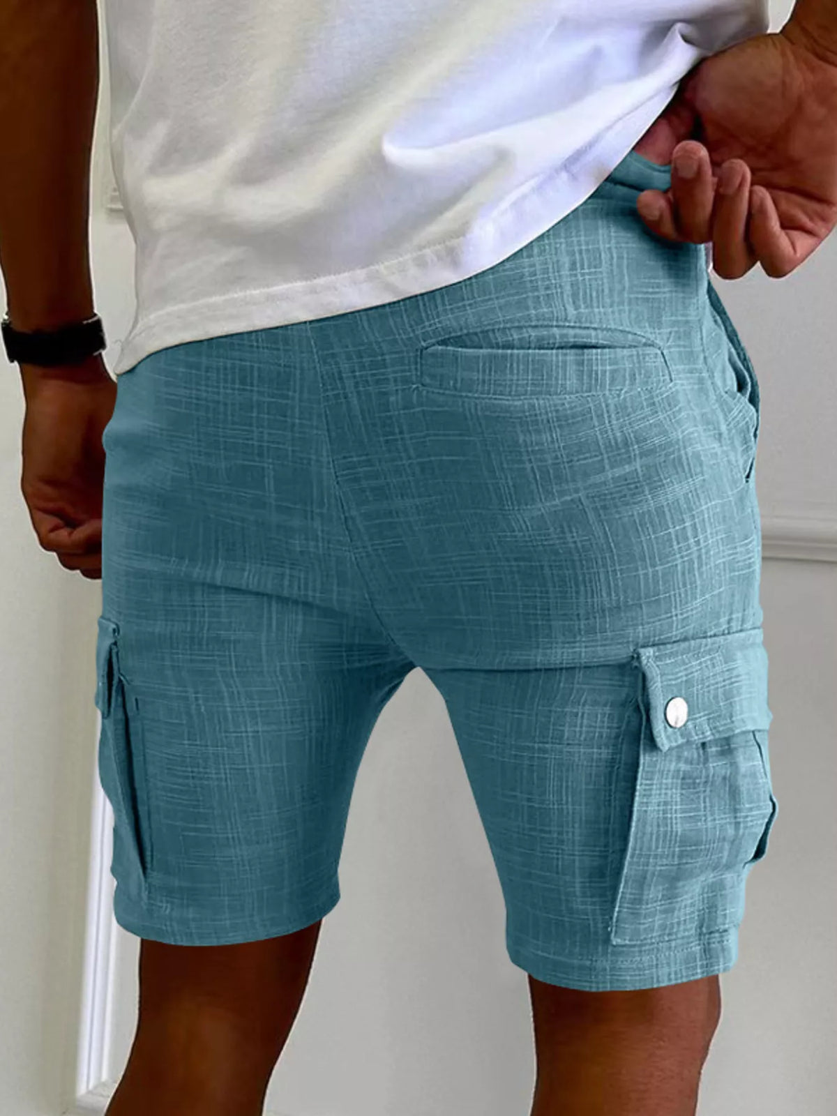 Men’s light blue cargo shorts with side cargo pocket and buttoned flap at hem.