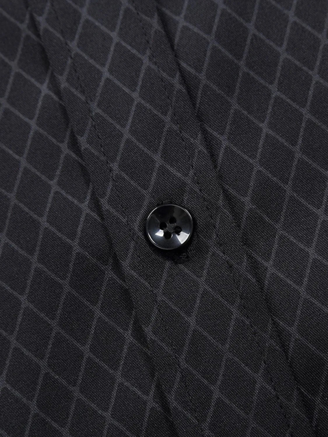 Men's collared short-sleeve shirt close-up, black micro-pattern with round button.