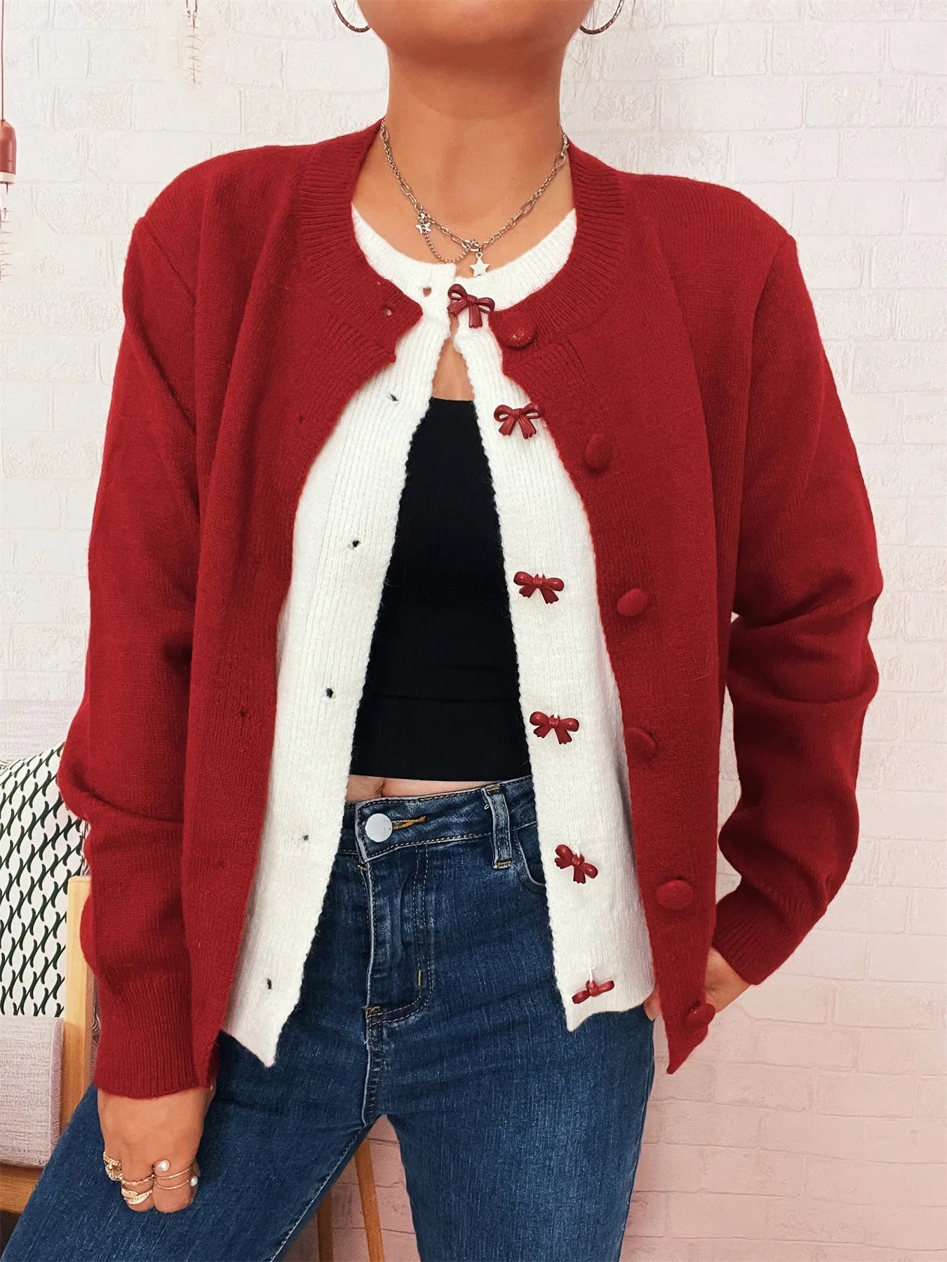 Red knit cardigan with long sleeves, button-front closure, and bow embroidery detail