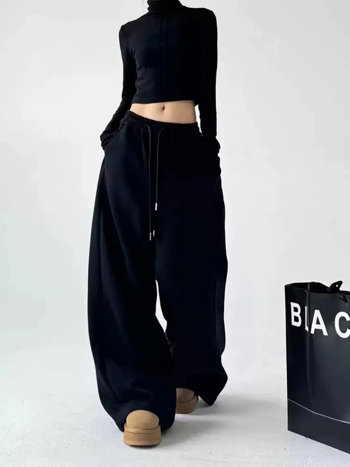 Black oversized wide-leg drawstring pants with elastic waistband and straight wide legs