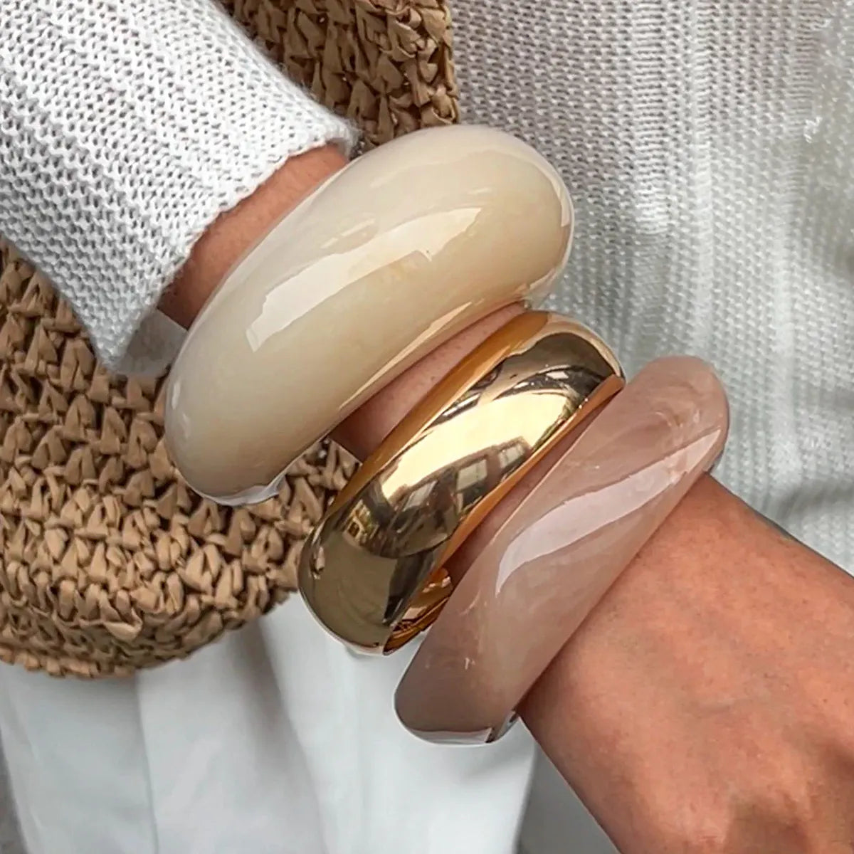 Chunky resin bangles set: cream, blush, gold-tone cuffs on hand