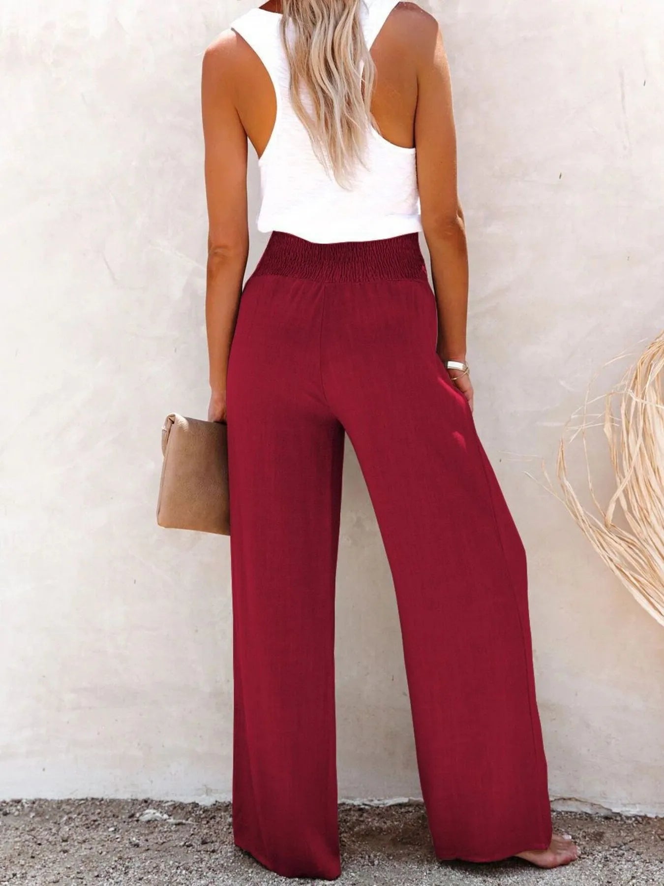 Burgundy high-waisted wide-leg pants with smocked waistband and textured fabric