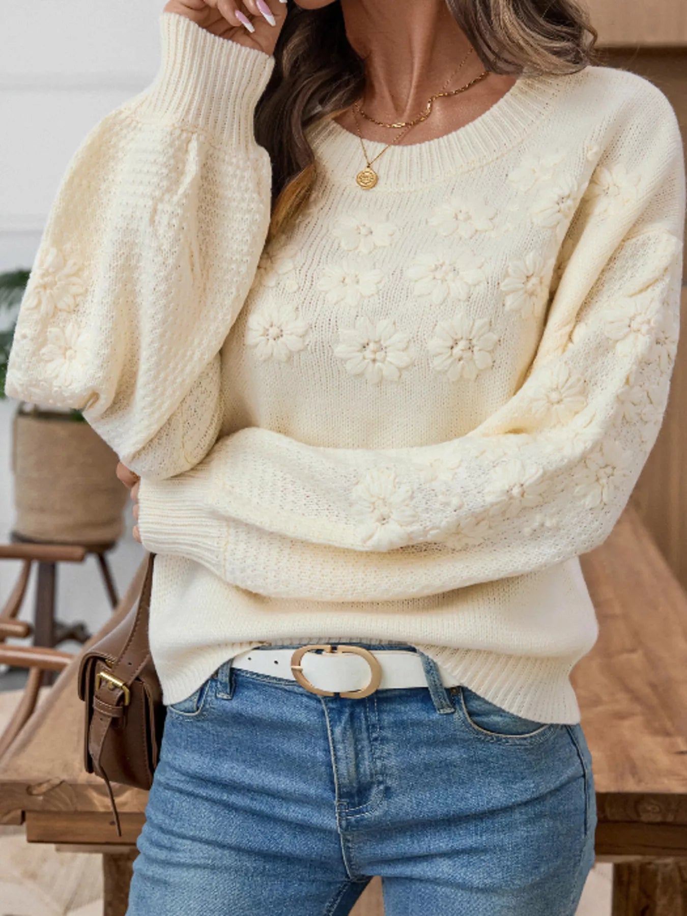 Cream floral knit sweater with round neck, long puff sleeves, and flower motifs