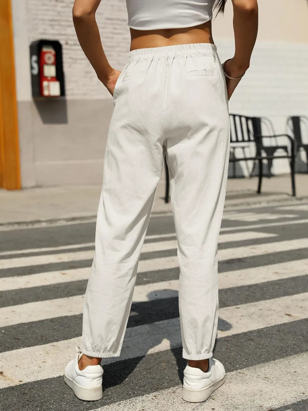 White elastic waist tapered pants with drawstring, cuffed ankle-length legs
