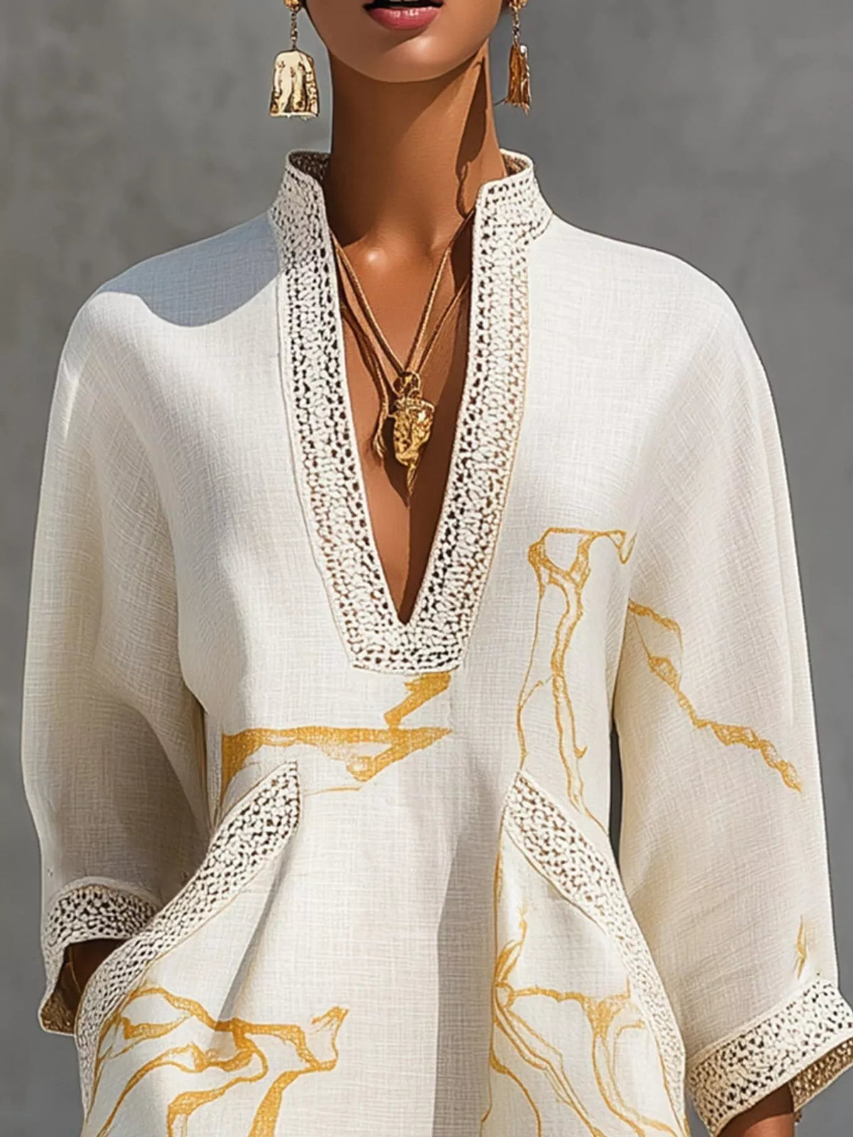 White mini dress with lace-trim V neckline and gold abstract motif