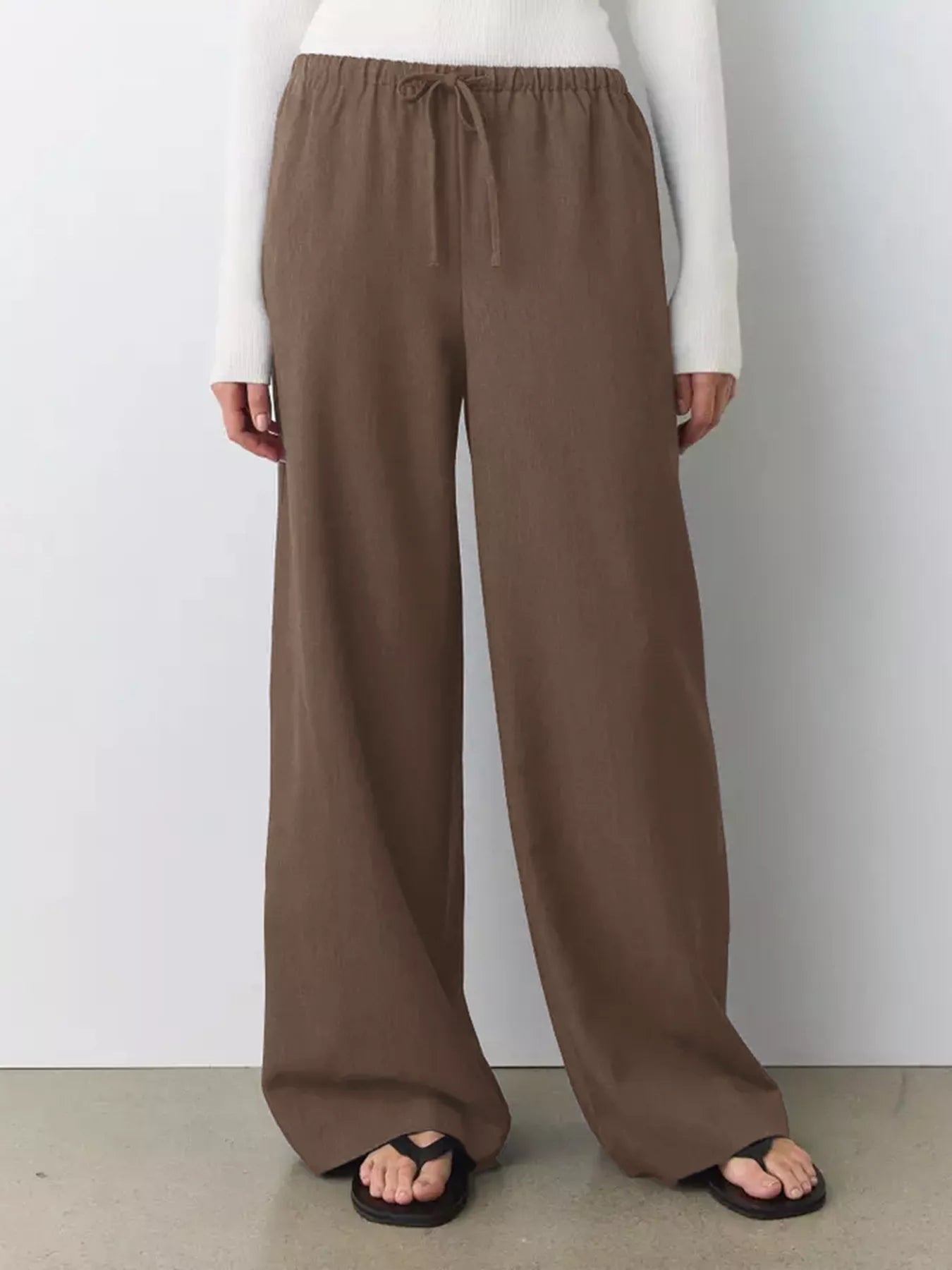 Brown wide-leg drawstring pants with elastic waistband and relaxed drape.