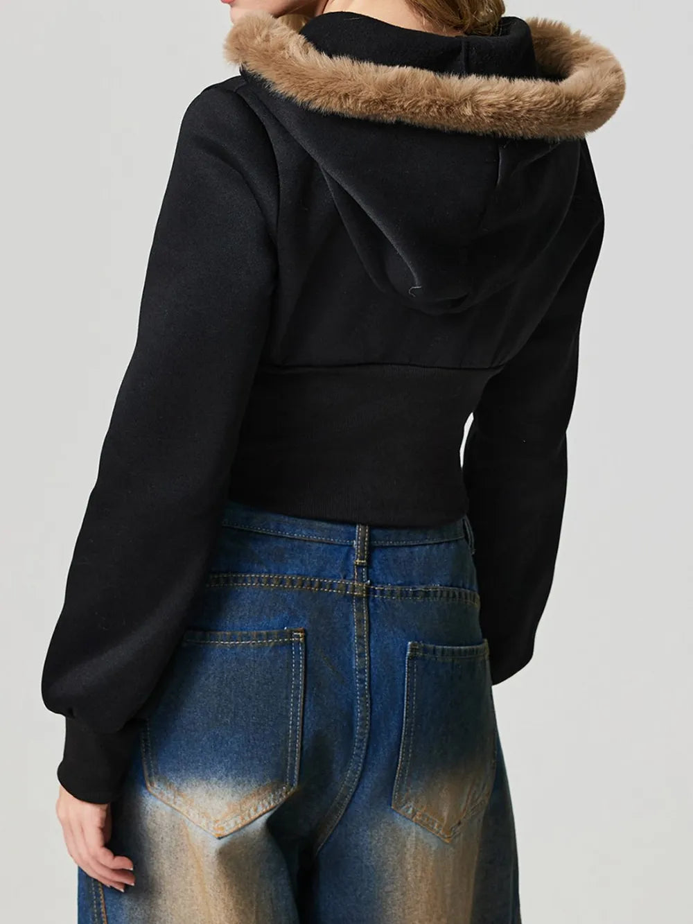 Black hooded zip-up jacket with fuzzy-trim hood and long sleeves, rear view.