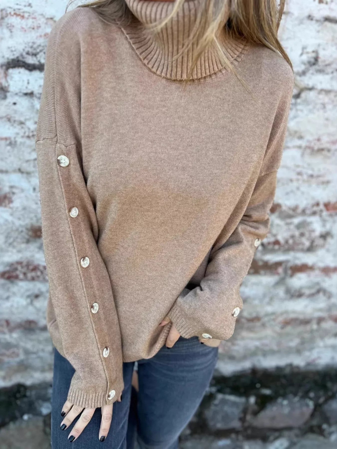 Tan turtleneck long-sleeve sweater with ribbed collar and buttoned cuffs
