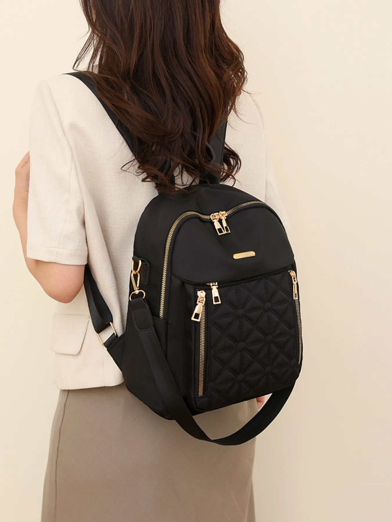 Black quilted oxford backpack with front and side zip pockets, adjustable shoulder strap