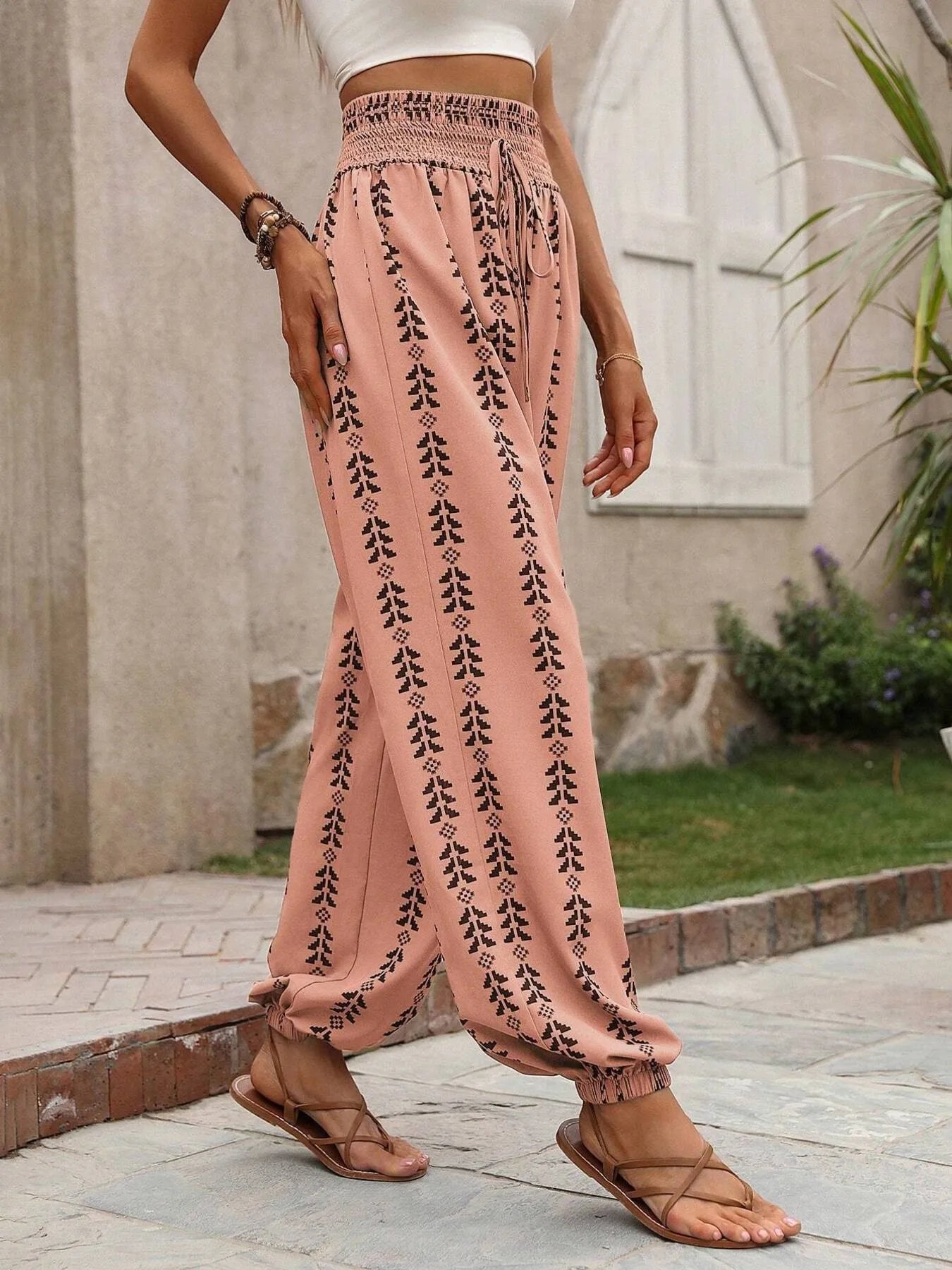 Pale blush wide-leg pants with black tree print, elastic waist and gathered ankles