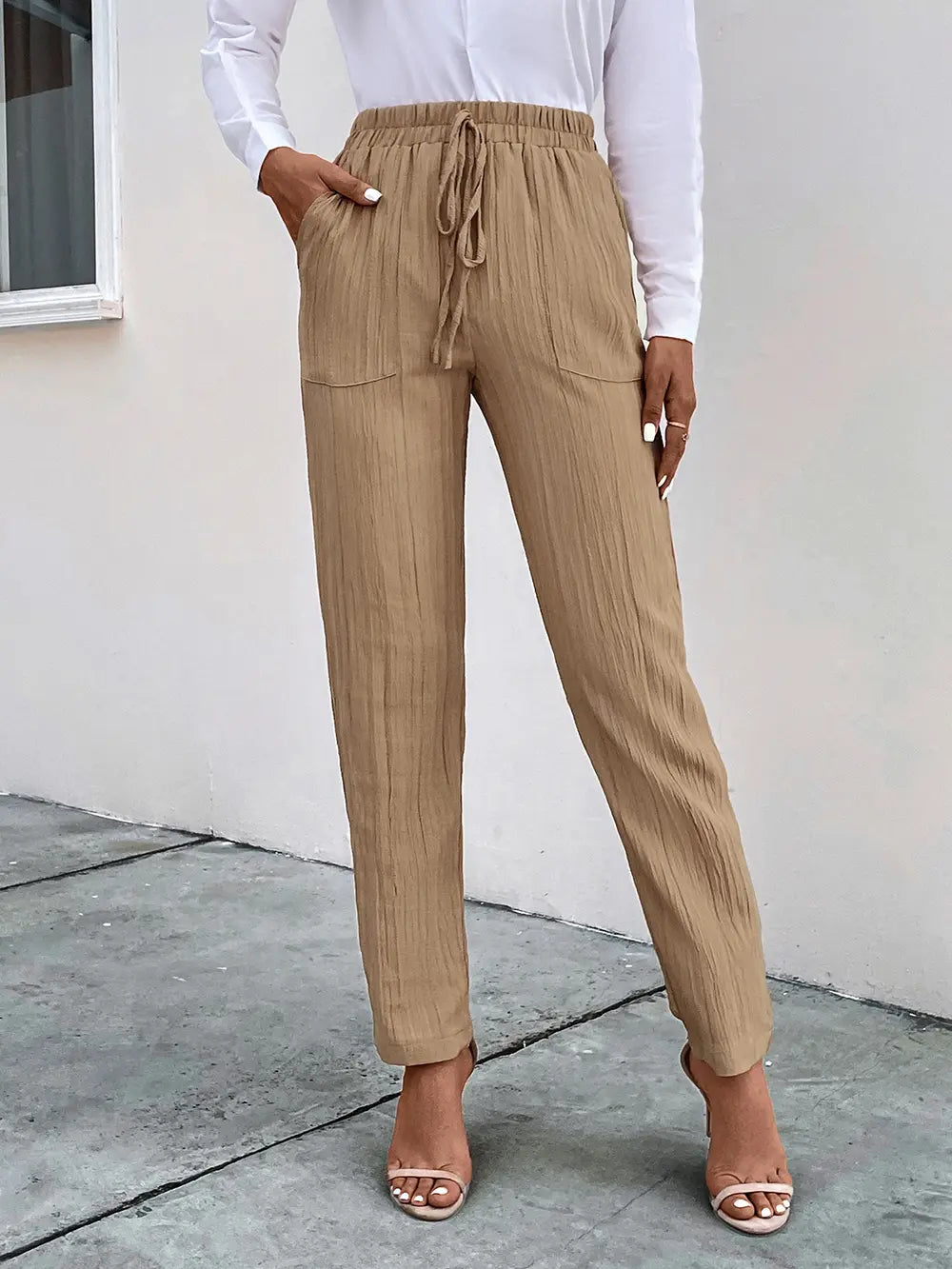 Tan textured drawstring pants with side pockets and ankle-length tapered legs