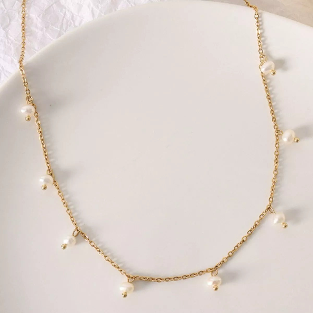 Gold-plated freshwater pearl necklace with evenly spaced pearls around the collar
