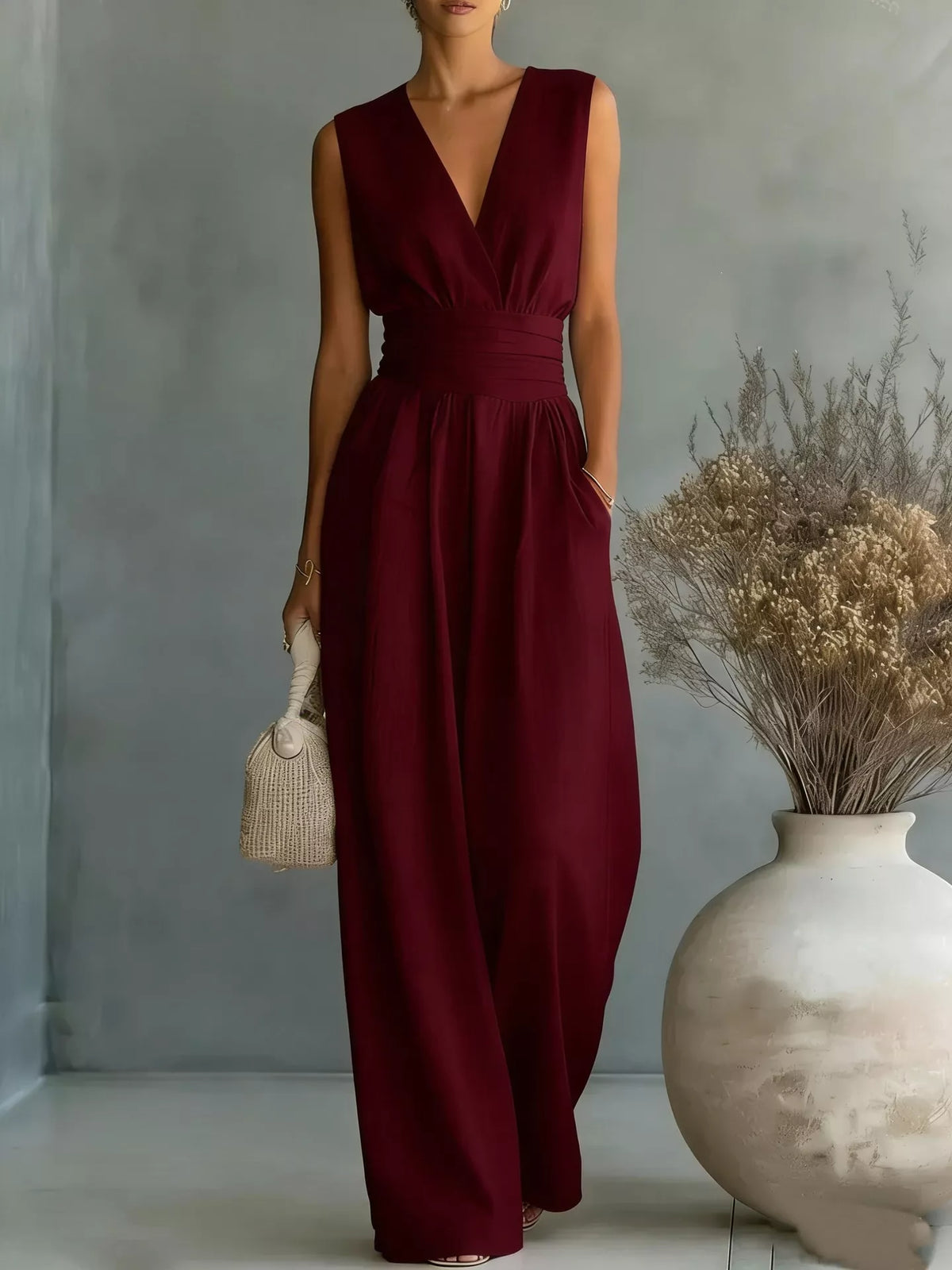 Burgundy sleeveless wide-leg jumpsuit with V-neck wrap bodice and gathered waist