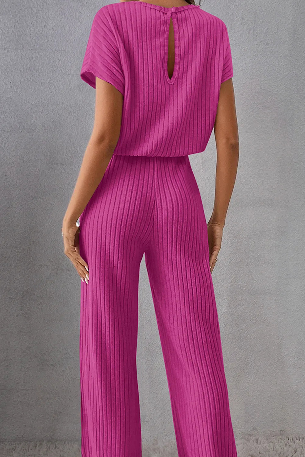 Hot pink ribbed knit jumpsuit with open-back keyhole and wide legs