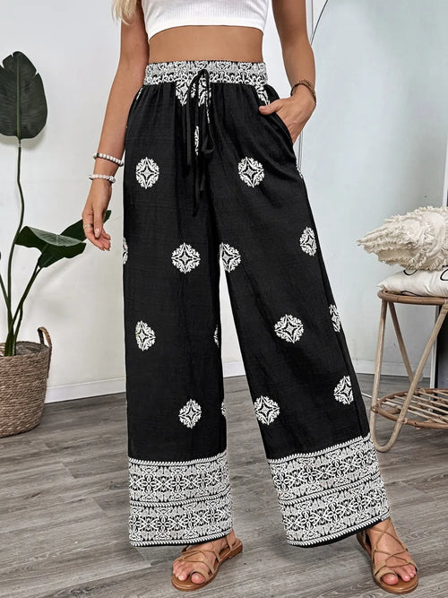 Black wide-leg pants with boho print, drawstring waist, white medallions and border
